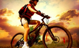 Happy Young Woman riding bicycle outside. Healthy Lifestyle